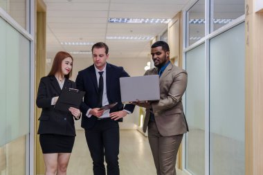 Çeşitli arkadaş ortaklar modern ofis koridorlarında yürümekten bahseder. Ofiste yürüyen ve konuşan kendine güvenen iş ortakları. Profesyonel iş adamları yürüyor ve konuşuyor.