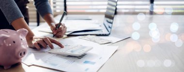 Modern ofisteki iş verilerini hesaplamak için hesap makinesi üzerinde çalışan iş kadını ya da muhasebeci. Muhasebeci kadın yatırım verilerini, mali ve vergi sistemleri kavramlarını analiz ediyor..