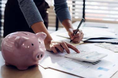 Modern ofisteki iş verilerini hesaplamak için hesap makinesi üzerinde çalışan iş kadını ya da muhasebeci. Muhasebeci kadın yatırım verilerini, mali ve vergi sistemleri kavramlarını analiz ediyor..