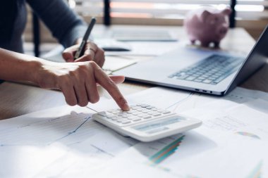 Modern ofisteki iş verilerini hesaplamak için hesap makinesi üzerinde çalışan iş kadını ya da muhasebeci. Muhasebeci kadın yatırım verilerini, mali ve vergi sistemleri kavramlarını analiz ediyor..