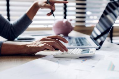 Modern ofisteki iş verilerini hesaplamak için hesap makinesi üzerinde çalışan iş kadını ya da muhasebeci. Muhasebeci kadın yatırım verilerini, mali ve vergi sistemleri kavramlarını analiz ediyor..
