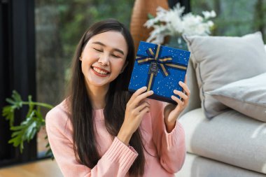 Kutuyu açan mutlu, gülümseyen genç bir kadın. Kadın Noel 'de hediyesini açıyor. Mutlu Noeller, mutlu tatiller. Neşeli genç bir bayan Noel hediyesi alıyor..