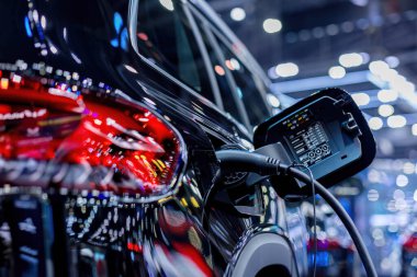 Elektrikli araba şarj istasyonu. Otoparktaki hibrit araba elektrik şarj istasyonu. Elektrikli araba park ve şarj istasyonunda şarj oluyor. Elektrik prizi. Ulaşım EV