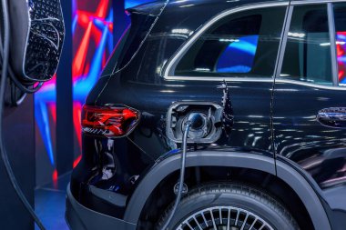 Elektrikli araba şarj istasyonu. Otoparktaki hibrit araba elektrik şarj istasyonu. Elektrikli araba park ve şarj istasyonunda şarj oluyor. Elektrik prizi. Ulaşım EV