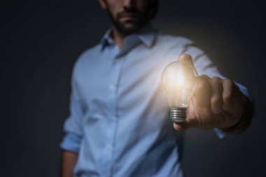 Businessman holding light bulb. Idea concept with innovation and inspiration. businessman holding illuminated light bulb. Brain creative thinking ideas and innovation concept.	
