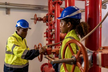 Engineer or technician work checking Fire suppression system and fire equipment. Engineer check red generator pump for water sprinkler piping and fire alarm control system