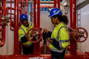 Engineer or technician work checking Fire suppression system and fire equipment. Engineer check red generator pump for water sprinkler piping and fire alarm control system