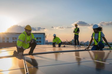 Fabrikanın çatısındaki güneş pilini kontrol et. Çatıda yürüyen mühendisler güneş pili panelini inceleyip kontrol ediyorlar. Çatıda çalışan mühendis teftiş kurulum güneş hücresi