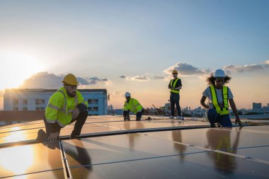 Fabrikanın çatısındaki güneş pilini kontrol et. Çatıda yürüyen mühendisler güneş pili panelini inceleyip kontrol ediyorlar. Çatıda çalışan mühendis teftiş kurulum güneş hücresi