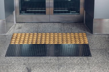 Paslanmaz çelik korkuluklu beton rampa tekerlekli sandalye engellileri destekliyor. Tekerlekli sandalyedeki engellileri desteklemenin yolu.