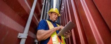 Ustabaşı ya da işçi konteyner kargo alanında çalışıyor. Konteynırdaki malları kontrol ediyor. Ustabaşı ya da işçi konteynırları kontrol ediyor. Lojistik ve nakliye