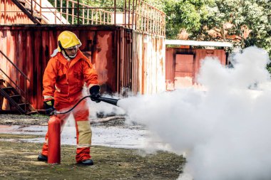 İtfaiyeci konsepti. Birkaç itfaiyeci bir yangın saldırısı için saldırıya geçiyor. İtfaiyeci ateş aleviyle savaşmak için su ve yangın söndürücü kullanıyor.. 