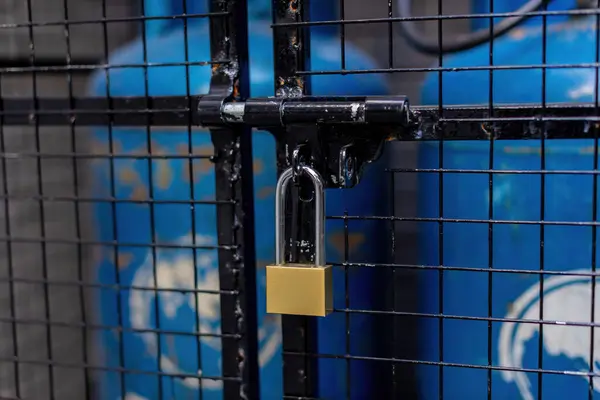 Padlock on closed doors. Door with lock. Lock on an old gate. Lock on a chain link security fence. Chicken wire fence gate is locked with a chain and a padlock.