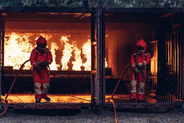 Firefighter Concept. Several firefighters go offensive for a fire attack. Fireman using water and extinguisher to fighting with fire flame.