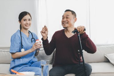 Bakıcı hemşire evde kanepede oturan kıdemli bir hastayla ilgilenir. Hemşire yaşlılara yardım ediyor. Kıdemli hastaya evde bakıcı hemşire tarafından tıbbi hizmet ziyareti yapılıyor. 