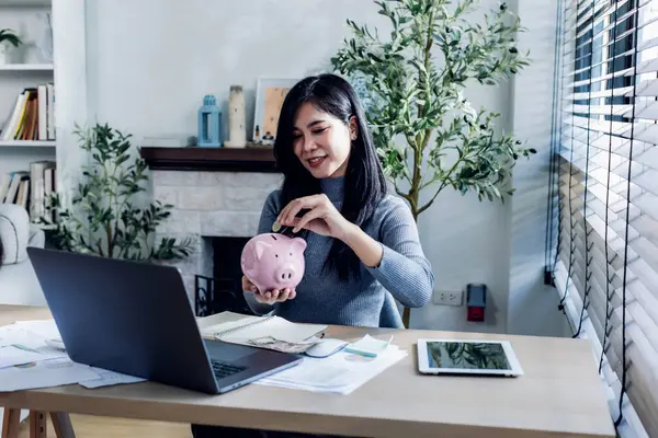 woman working from home concept saving money for finance accounting. Saving money wealth concept, Asian business woman hand write management budget for saving cost, cash finance