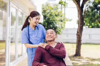 Bakıcı hemşire evin dışında yaşlı bir hastayla ilgileniyor. Hemşire yaşlılara yardım ediyor