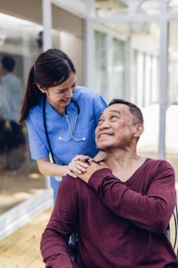 Bakıcı hemşire evin dışında yaşlı bir hastayla ilgileniyor. Hemşire yaşlılara yardım ediyor