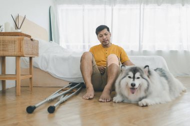 Evde, Livingroom 'da köpekli bir adam var. Evcil hayvan evde yaşarken bir ilham kaynağı oluyor. Sevimli hayvan. Köpek ve adam sahibi.