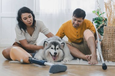 Evde köpek gibi otururken çiftler kaynaşıyor ve gülümsüyor. Evde köpekle yatakta oturan çift. Oturma odasında oturan protez bacaklı çift. Gündelik giyinen sevgili çift yatak odasında dinleniyor.