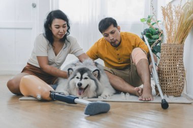 Evde köpek gibi otururken çiftler kaynaşıyor ve gülümsüyor. Evde köpekle yatakta oturan çift. Oturma odasında oturan protez bacaklı çift. Gündelik giyinen sevgili çift yatak odasında dinleniyor.