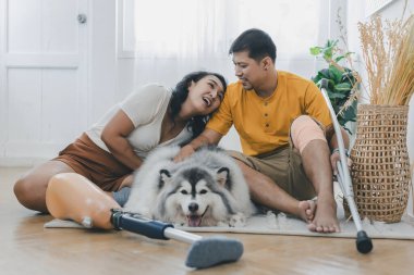 Evde köpek gibi otururken çiftler kaynaşıyor ve gülümsüyor. Evde köpekle yatakta oturan çift. Oturma odasında oturan protez bacaklı çift. Gündelik giyinen sevgili çift yatak odasında dinleniyor.