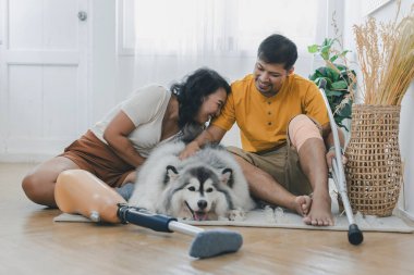 Evde köpek gibi otururken çiftler kaynaşıyor ve gülümsüyor. Evde köpekle yatakta oturan çift. Oturma odasında oturan protez bacaklı çift. Gündelik giyinen sevgili çift yatak odasında dinleniyor.