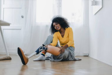 Protez bacaklı bir kadın evde fizik tedavi egzersizi yapıyor. Yürümek için protez takan bir kadın..