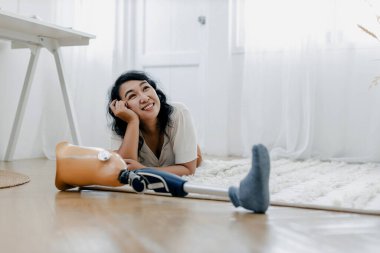 Yatak odasında protez bacağını tutmaya çalışan bir kadın. Özürlü ve protez bacaklı insanlar. Engelli kadın yatak odasında protez bir bacak almaya çalıştı.