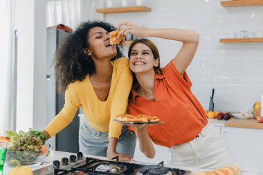 Gururlu LGBT Ailesi mutfakta, gülen surat. Evde aile yemeği hazırlıyorum. Mutlu gülümseyen aile mutfakta birlikte yemek yaparken eğleniyor. Aile hayatı. Birlikte mutluyuz, mutfakta yemek yapıyoruz..