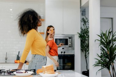 Gururlu LGBT Ailesi mutfakta, gülen surat. Evde aile yemeği hazırlıyorum. Mutlu gülümseyen aile mutfakta birlikte yemek yaparken eğleniyor. Aile hayatı. Birlikte mutluyuz, mutfakta yemek yapıyoruz..