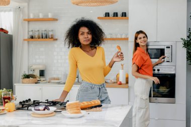 Gururlu LGBT Ailesi mutfakta, gülen surat. Evde aile yemeği hazırlıyorum. Mutlu gülümseyen aile mutfakta birlikte yemek yaparken eğleniyor. Aile hayatı. Birlikte mutluyuz, mutfakta yemek yapıyoruz..