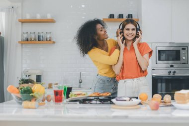 Gururlu LGBT Ailesi mutfakta, gülen surat. Evde aile yemeği hazırlıyorum. Mutlu gülümseyen aile mutfakta birlikte yemek yaparken eğleniyor. Aile hayatı. Birlikte mutluyuz, mutfakta yemek yapıyoruz..