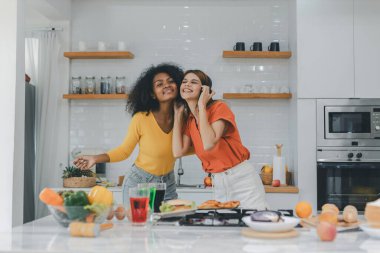 Gururlu LGBT Ailesi mutfakta, gülen surat. Evde aile yemeği hazırlıyorum. Mutlu gülümseyen aile mutfakta birlikte yemek yaparken eğleniyor. Aile hayatı. Birlikte mutluyuz, mutfakta yemek yapıyoruz..