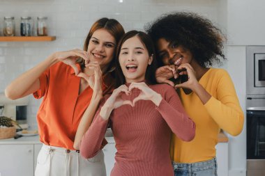 Mutfak odasında kucaklaşan çok ırklı lezbiyen çift. Yüzük tutan siyah beyaz bir çift. Afro-Amerikan ve beyaz lezbiyen çift birbirlerine şefkatle sarılıp bakıyorlar.