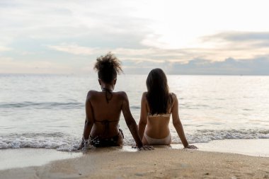 Yaz tatilinde kumsalda bir kadın. Tropik bir plajda güneşlenen güzel bir kız. Kumlu sahilde bikinili bir kadın turist. Cennetteki tropik plajda seksi bikinili kadın.