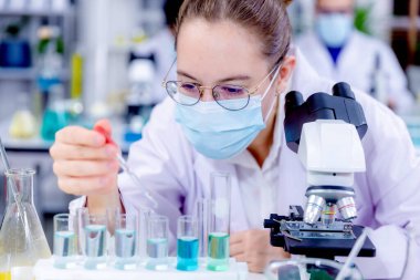 Bilimadamı ve bilim sınavındaki insanlar, deney ya da laboratuvar ödevi için test ya da grup projesi. Bilim laboratuarında çalışan bilim adamı ya da eczacı. Tıbbi Geliştirme Laboratuarı. 