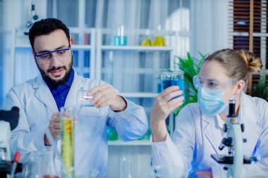 Bilimadamı ve bilim sınavındaki insanlar, deney ya da laboratuvar ödevi için test ya da grup projesi. Bilim laboratuarında çalışan bilim adamı ya da eczacı. Tıbbi Geliştirme Laboratuarı. 