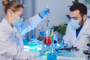 Bilimadamı ve bilim sınavındaki insanlar, deney ya da laboratuvar ödevi için test ya da grup projesi. Bilim laboratuarında çalışan bilim adamı ya da eczacı. Tıbbi Geliştirme Laboratuarı. 