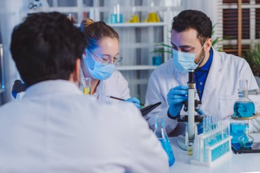 Bilimadamı ve bilim sınavındaki insanlar, deney ya da laboratuvar ödevi için test ya da grup projesi. Bilim laboratuarında çalışan bilim adamı ya da eczacı. Tıbbi Geliştirme Laboratuarı. 