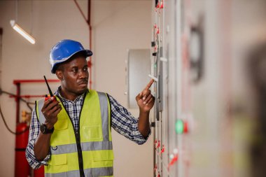 Electrical engineer working in control room. Electrical engineer man checking Power Distribution Cabinet in the control room