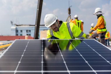 Fabrikanın çatısındaki güneş pilini kontrol et. Çatıda yürüyen mühendisler güneş pili panelini inceleyip kontrol ediyorlar. Çatıda çalışan mühendis teftiş kurulum güneş hücresi