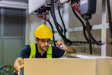 Electrical engineer working in control room. Electrical engineer man checking Power Distribution Cabinet in the control room	