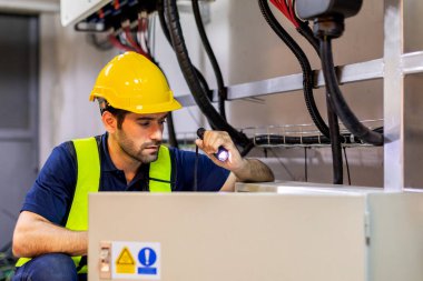 Electrical engineer working in control room. Electrical engineer man checking Power Distribution Cabinet in the control room	