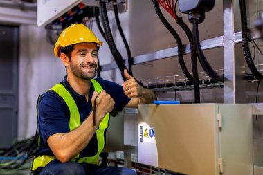 Kontrol odasında çalışan elektrik mühendisi. Elektrik mühendisi kontrol odasındaki güç dağıtım dolabını kontrol ediyor.