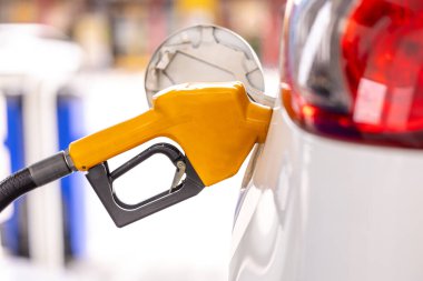 Benzini istasyonda doldur ve doldur. Benzin istasyonu, yakıt ikmali. Makineyi yakıtla doldurmak için. Benzin istasyonunda benzinle dolu bir araba. Benzin istasyonu pompası. 