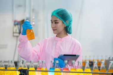 Worker Checking quality or checking stock of glass bottle in beverage factory. Worker QC working in a drink water factory 