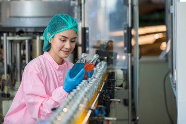 Worker Checking quality or checking stock of glass bottle in beverage factory. Worker QC working in a drink water factory 