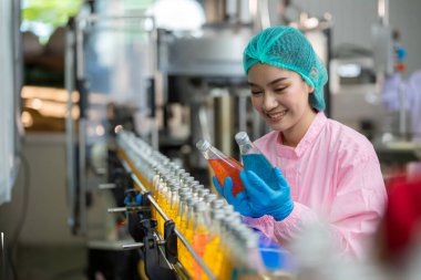 Worker Checking quality or checking stock of glass bottle in beverage factory. Worker QC working in a drink water factory 