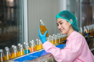 Worker Checking quality or checking stock of glass bottle in beverage factory. Worker QC working in a drink water factory 